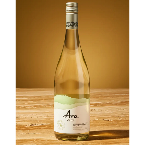 Butelka bezalkoholowego wina Guiltfree Ara Zero Sauvignon Blanc na marmurowym blacie w ciepłym świetle.