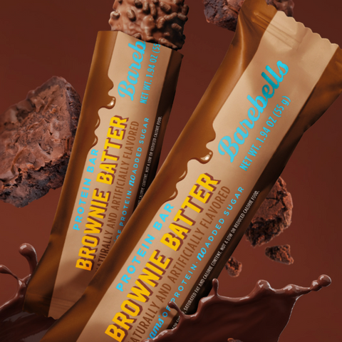Guiltfree baton proteinowy Barebells Brownie Batter w brązowym opakowaniu z rozpryskującą się czekoladą w tle