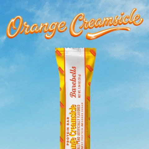 Baton proteinowy Guiltfree Barebells Orange Creamsicle w żółtym opakowaniu na tle błękitnego nieba