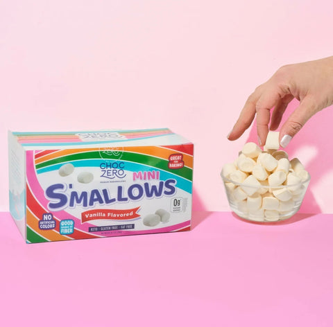 Guiltfree Choc Zero waniliowe mini pianki marshmallow bez cukru w opakowaniu i szklanej miseczce na różowym tle