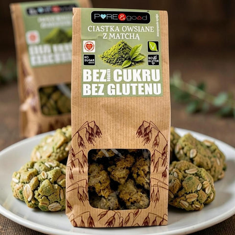 Guiltfree ciastka owsiane z matchą w papierowym opakowaniu na talerzu, bezglutenowe i bez dodatku cukru.