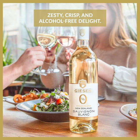 Butelka bezalkoholowego wina Giesen 0% Sauvignon Blanc na stole w restauracji w otoczeniu sałatki i wznoszonych kieliszków