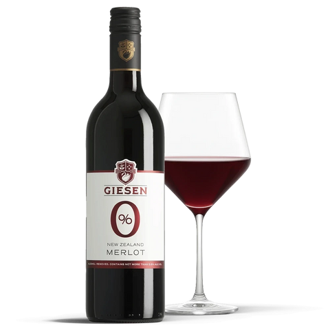 Butelka bezalkoholowego wina Guiltfree Giesen Merlot 0% z kieliszkiem wypełnionym czerwonym winem na czarnym tle.