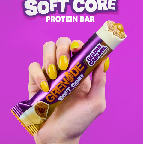 Guiltfree baton proteinowy Grenade Soft Core Golden Caramel w białej czekoladzie trzymany w dłoni z żółtym manicure