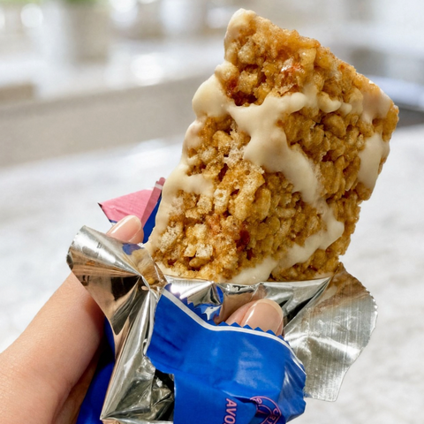 Guiltfree Magic Spoon baton proteinowy o smaku truskawkowego shake'a z chrupiącą bazą i kremową polewą w dłoni