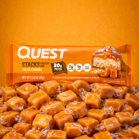 Guiltfree baton proteinowy Quest Stacks Salted Caramel leżący na stosie cukierków toffi w pomarańczowej tonacji