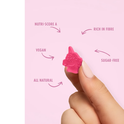 Dłoń trzymająca różowy żelek w kształcie jednorożca Sweet Switch z Guiltfree, z opisami cech produktu na tle.